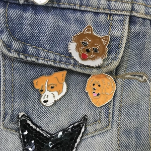 Detail of colorful zinc alloy dog enamel pins pinned on a blue denim jacket pocket