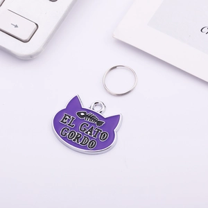 Detailed view of cat-shaped purple enamel pet ID tag with fishbone and EL GATO GORDO text