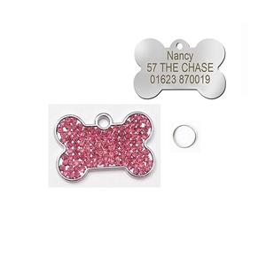 Macro detail of bone-shaped pet ID tags with pink rhinestones and custom laser engraving