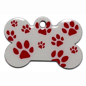 Detailed view of bone-shaped pet ID tag with red paw prints on white metal surface