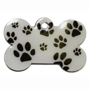 Bone shaped pet ID tag with black paw prints on a white glossy finish surface
