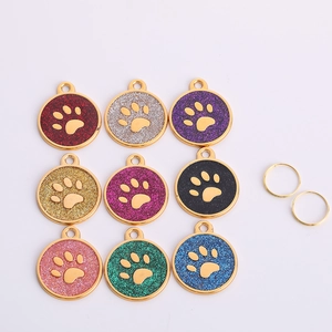Macro detail of nine colorful glitter pet ID tags with paw print design and rings