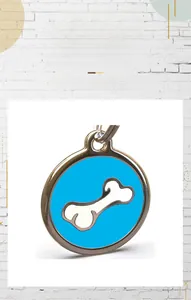 Macro shot of circular blue pet tag with white bone icon and metal attachment ring