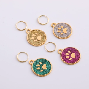 Detailed view of paw print pet ID tags in gold and silver glitter finishes