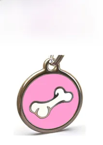 Detailed macro view of a round pink enamel dog ID tag with a white bone motif and metal ring