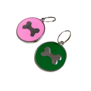 Pink and green round pet ID tags with bone emblems on a clean white background