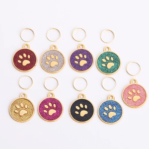 Set of colorful paw print pet ID tags with glitter finish and gold metal frame