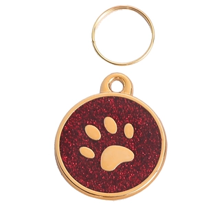 Golden pet ID tag with red glitter and paw print design on a white background