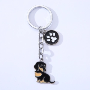 Detail of silver dachshund metal keychain with enamel paw print charm and dog pendant
