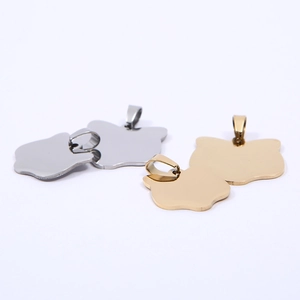 Macro shot of polished gold and silver cat-shaped stainless steel pet ID tag pendants