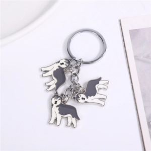 Détail de porte-clés chien Husky avec breloques en émail sur anneau en métal argenté