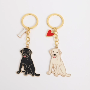 Detail van Labrador sleutelhangers in zwart en crème email met bot- en hartbedeltjes