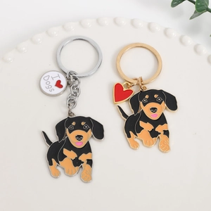 Teckel sleutelhangers in goud en zilver met I Heart Dogs bedeltjes op een dienblad