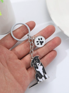 Detail of silver border collie keychain with black and white enamel paw charm