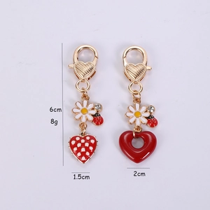 Detail showing heart-shaped daisy keychain dimensions with red ladybug and crystal inlay