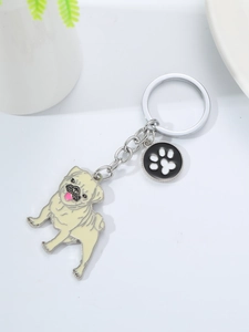Close-up of cute cartoon pug keychain with paw print charm and silver metal ring