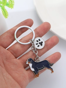 Detailed close-up of enamel Bernese Mountain Dog keychain with heart paw print charm