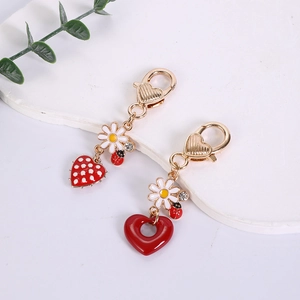 Detailed close-up of cute strawberry and heart charms with daisy and ladybug accents