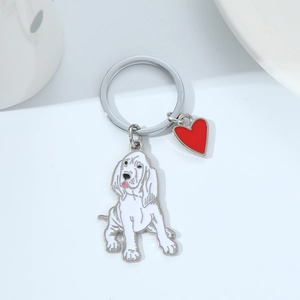 Close-up of metal keychain featuring enamel dog pendant and a small red heart charm