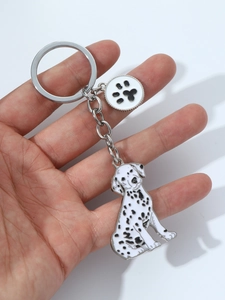 Detailed view of spotted dog and paw print alloy pendants on a metal keychain