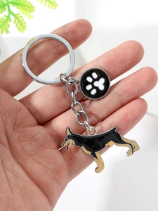 Close-up of Doberman keychain with enamel dog charm and white paw print pendant