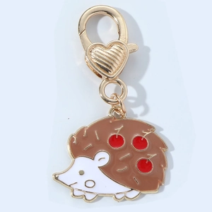 Detail of cute hedgehog keychain with red cherry accents and heart lobster clasp