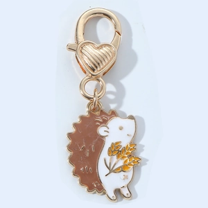 Cute enamel hedgehog keychain with golden heart lobster clasp on white background