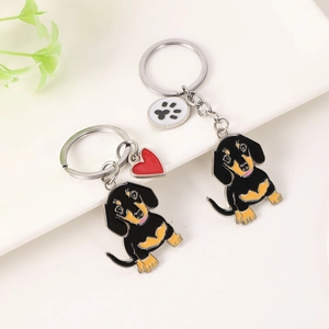 Détails de porte-clés teckel en émail avec pendentifs cœur et patte sur plateau blanc