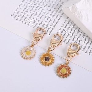 Three colorful daisy flower pendants with heart-shaped clasps on zinc alloy keychains