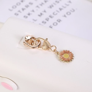 Detailed close-up of golden sunflower keychain with red enamel petals and heart-shaped connector