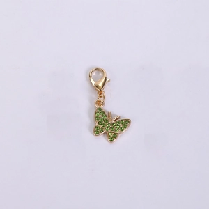 Detail of a golden butterfly keychain with green crystal accents and lobster clasp