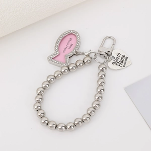 Detail of silver beaded keychain with heart charm and rhinestone fish photo frame