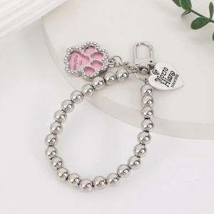Detail of silver bead bracelet with heart tag and rhinestone-encrusted paw photo frame