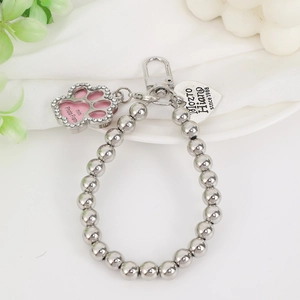 Detailed shot of beaded metal charm featuring a pink glitter cat paw mini photo frame