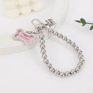 Detail of beaded necklace with silver heart tag and rhinestone bone-shaped mini photo frame