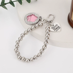 Detailed macro view of silver beaded keychain with heart charm and photo locket pendant
