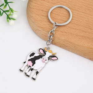 Porte-clés vache mignonne en métal sur fond blanc avec décorations élégantes