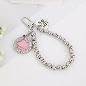 Macro detail of silver beaded keychain with heart tag and mini photo frame charm