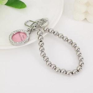 Macro detail of silver heart pendant with rhinestones and engraved metal tag