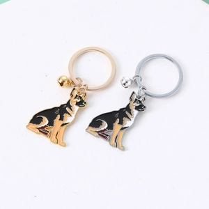 Detailed view of metal German Shepherd keychains with gold and silver bells