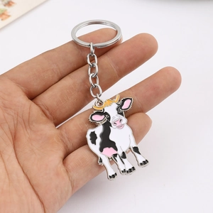 Gros plan d'un porte-clés vache mignon avec finition émail noir et blanc à la main