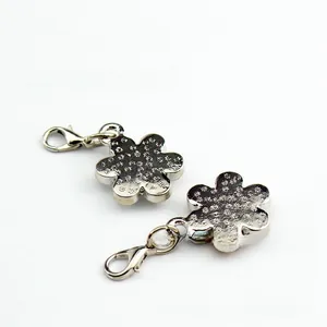 Detail of silver plum flower pet ID tags with lobster clasps and textured metal finish
