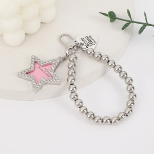 Macro detail of silver bead chain with rhinestone star frame and heart pendant