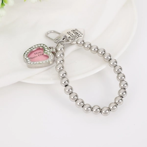 Detailed view of silver beaded charm with heart photo frame and engraved tag