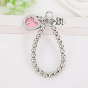 Detail view of heart frame pendant with rhinestones and engraved silver tag charm