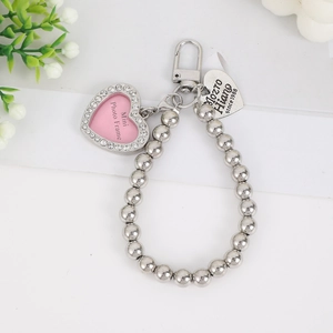 Silver beaded keychain with pink rhinestone photo frame and heart charm on white background