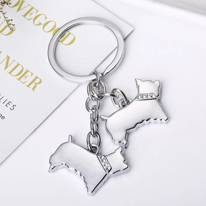 Détail du porte-clés double chien argenté avec colliers incrustés de cristaux brillants