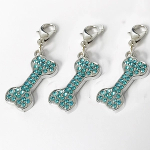 Three bone-shaped dog pendants with blue rhinestones and lobster clasps for pet collars