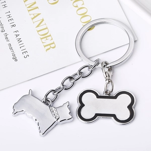 Détail d'un porte-clés argenté avec terrier en strass et pendentif en os émaillé noir