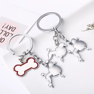 Porte-clés caniche en métal poli avec pendentif en forme d'os blanc en gros plan